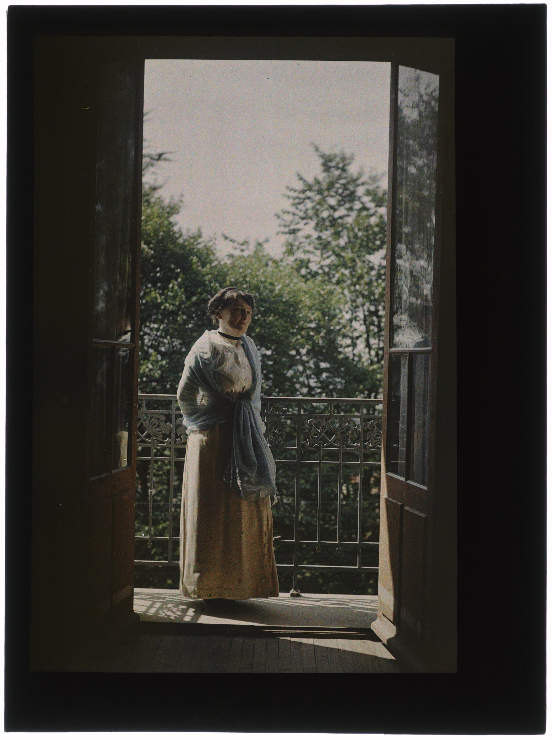 Portrait de femme au balcon ouvert sur le jardin