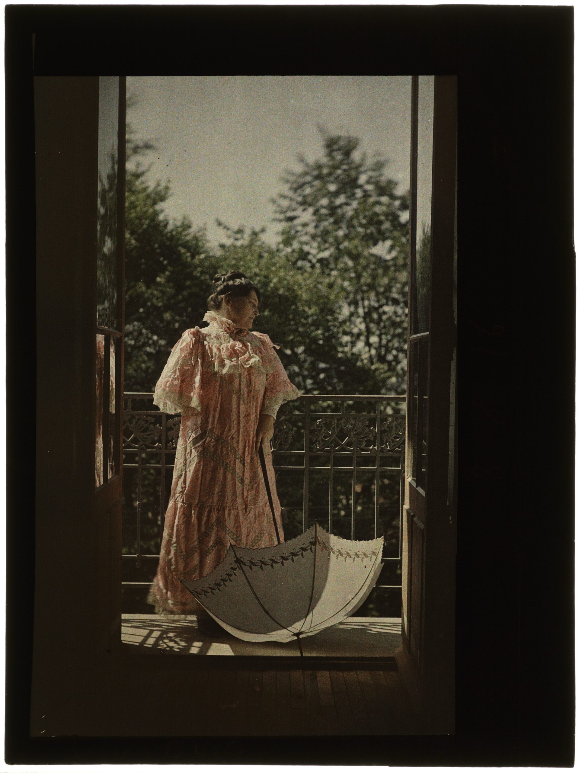 Portrait de femme au balcon ouvert sur le jardin