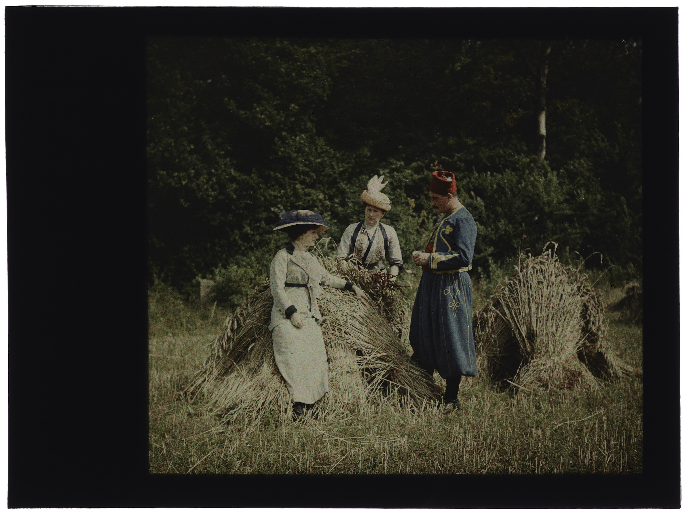 Deux femmes dans les champs moissonnés avec un soldat