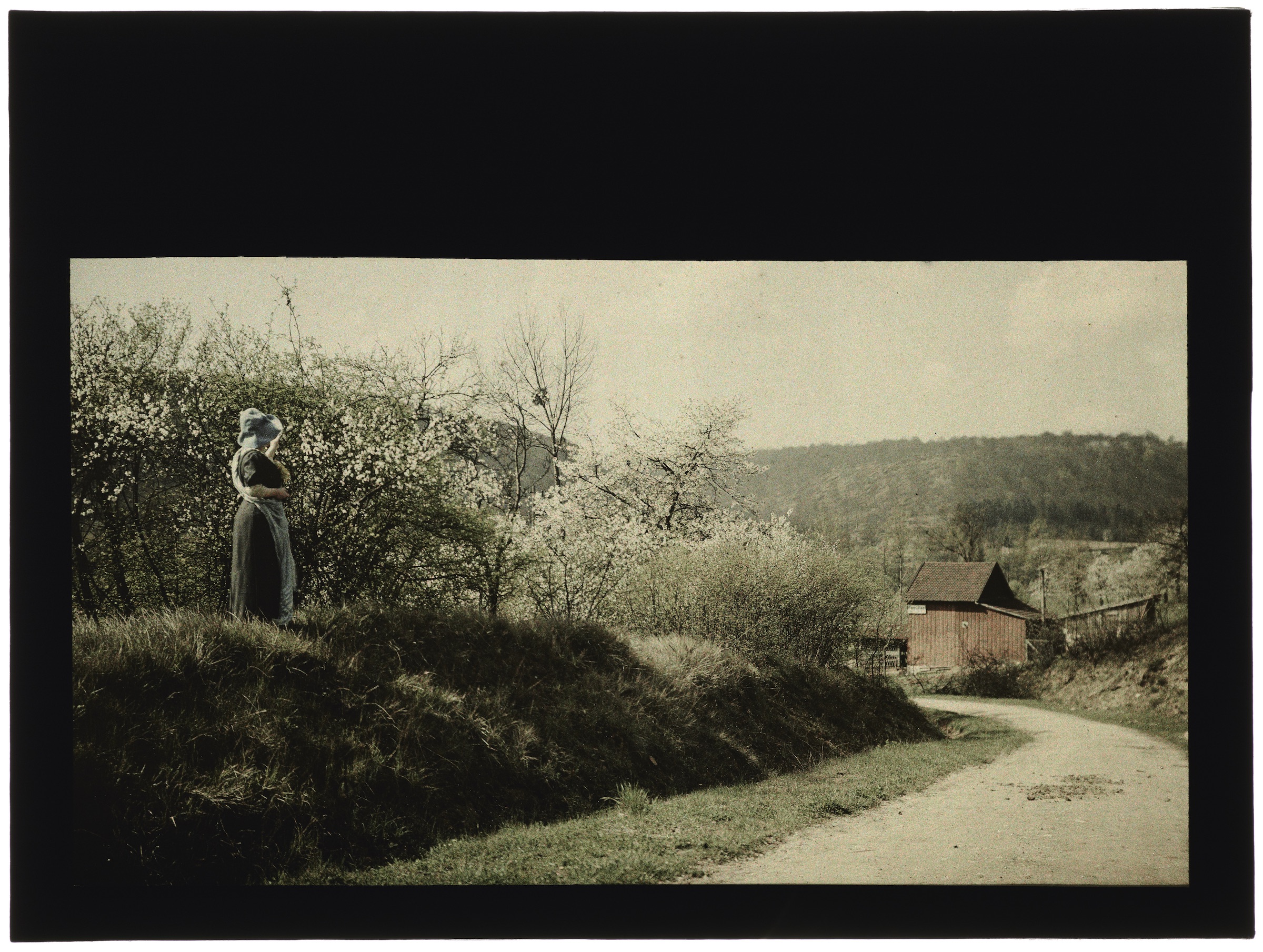 Femme dans la campagne avec village en arrière plan