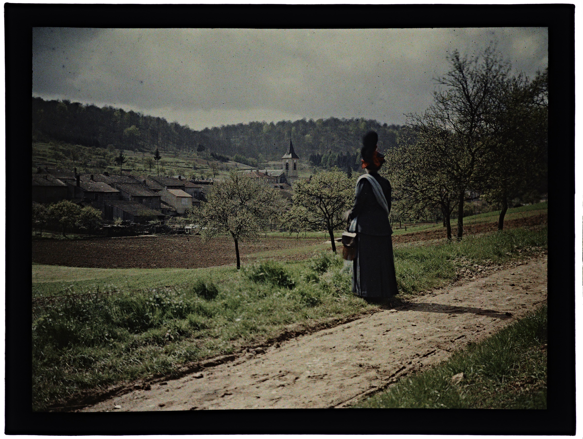 Une ou deux femmes dans la campagne avec village en arrière plan