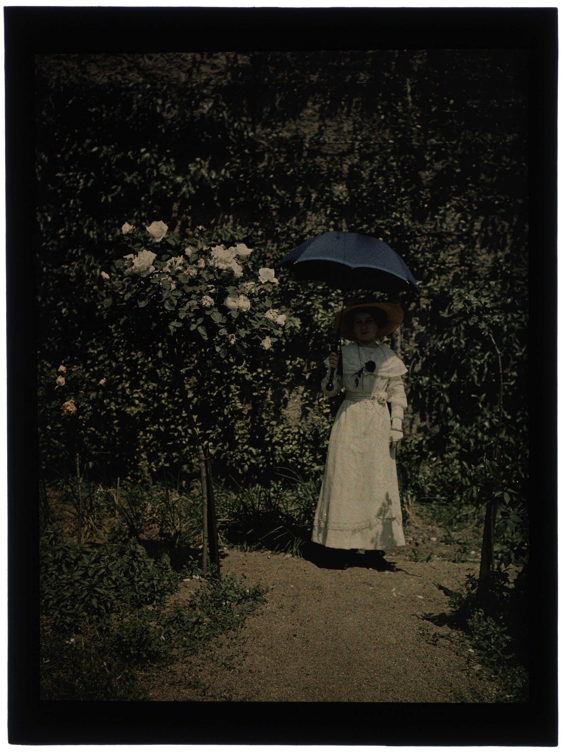 Femme au jardin devant la tonnelle